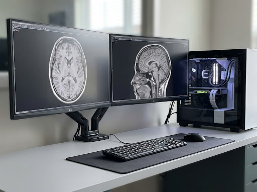 Realistic modern medical imaging workstation with dual MRI monitors and high-end PC.